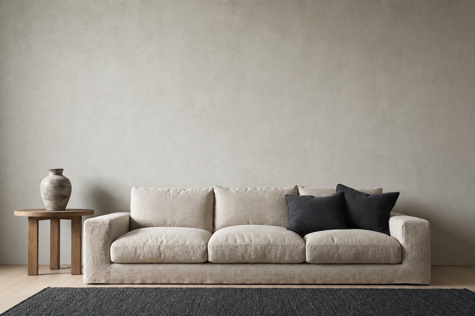 A bare plaster wall above a linen sofa